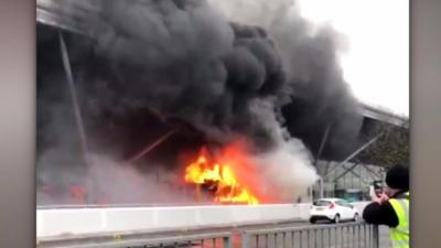 Stansted Airport has evacuated parts of its terminal after a fire in a bus outside the building.