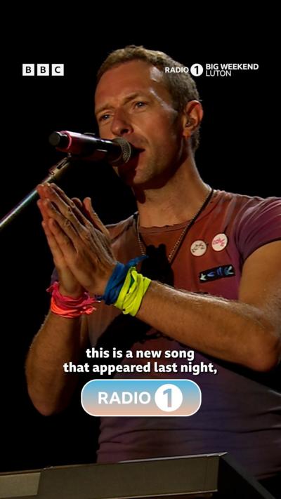 Coldplay at Radio 1 Big Weekend festival. The stage is lit up with colour.