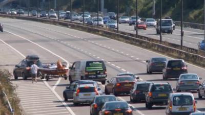 Boat being driven across three lanes of motorway traffic