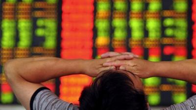 A stock investor covers his eyes at a brokerage house in Fuyang in central China