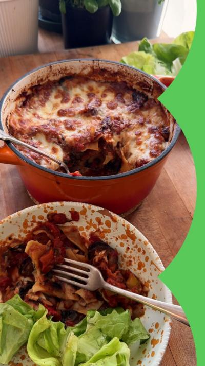 A bowl of lasagne in front of a pan of lasagna