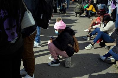 Migrants sit outside the facilities of the Commission for Refugee Assistance.