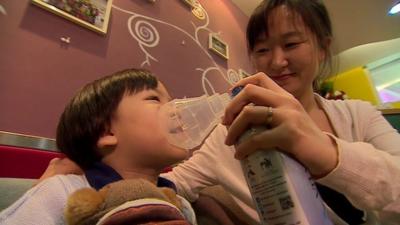 Li Tianqin gives her daughter canned air from the Canadian Rockies