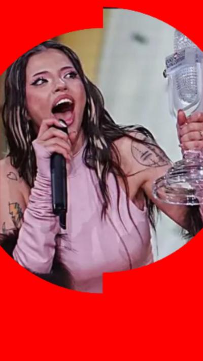 Bulgarian singer Dara has long dark hair and is wearing a pink top, holding a trophy.