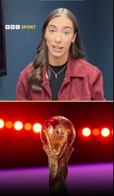 Faith has long brown hair is in the top half of the picture. She is wearing a red jacket and black top and a silver chain with an F charm. The World Cup is in the bottom half illuminated by bulbs behind and a purple backdrop. 