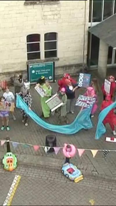 People dancing with signs and bunting.