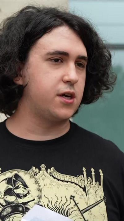 Student stands outside college holding results