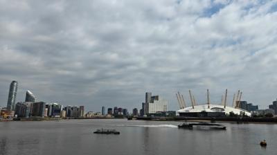 A cloudy sky over the Millennium Dome, skyscrapers and the River Thames