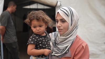 Gaza resident with her child - a still shot taken from a video interview