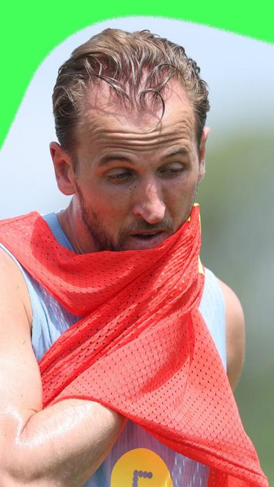 Harry Kane wiping sweat from his face with a training bib