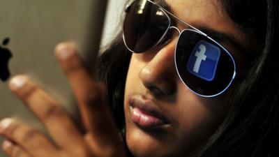 Young Indian woman browses Facebook on her tablet