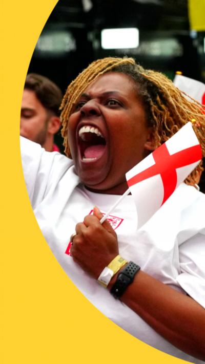 An England fan, in white shirt and holding an England flag, shouts