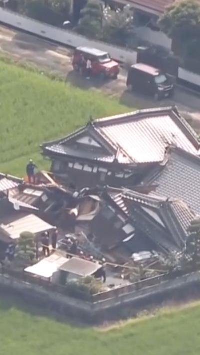 A damaged building is seen surrounded by green grass.