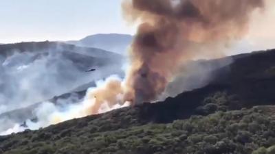 Helicopter dropping water over wildfire