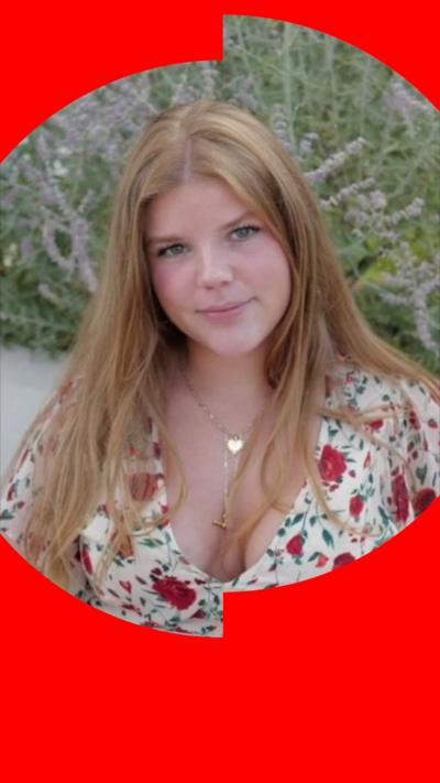 A young woman with long blonde hair wearing a flowery dress.