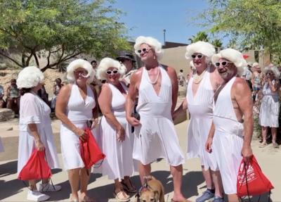 A group of people dressed in white dresses and wigs posing as Marilyn Monroe lookalikes.