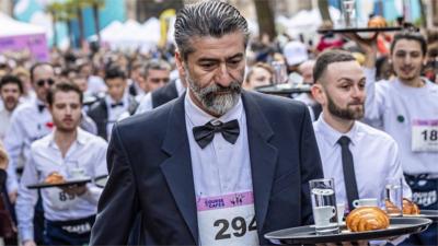 Waiters hold their trays as they take part in the race in Paris.