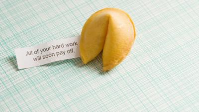 A fortune cookie alongaside a note saying "All of your hard work will soon pay off"