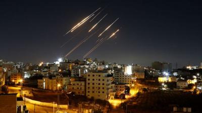 Streaks of light from Iranian ballistic missiles are seen in the night sky above Hebron, West Bank