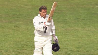 Robin Smith of Hampshire raising his cricket bat in the air and holding his helmet