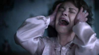 A woman screaming in a scene from The Little Stranger