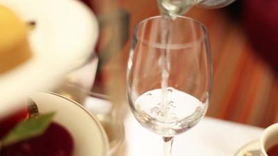 Wine glass with water being poured in