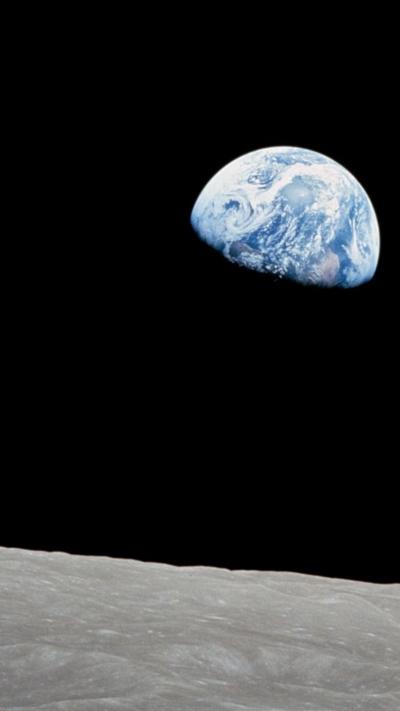 Planet Earth seen from space. It looks blue with white swirls and is surrounded by black