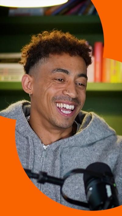 A man in a grey hoody smiling