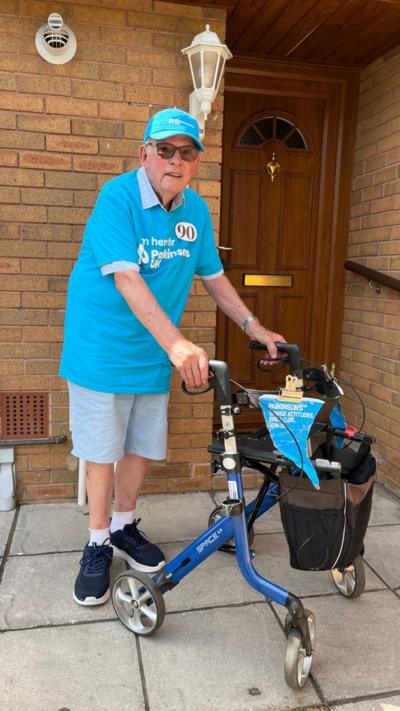 Man in blue t-shit and hat with walking frame