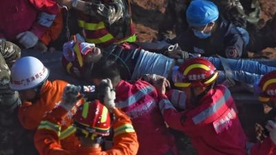 Survivor being stretchered from rubble