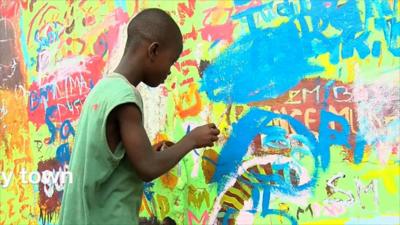 An artist boy painting in Ghana's capital, Accra