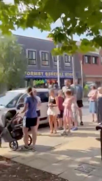 People stood in a queue on a UK town's High Street