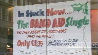 A sign in a shop window advertising the Band Aid single.