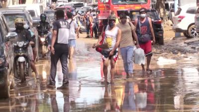 Residents walk through a flooded street in the Philippine capital Manila