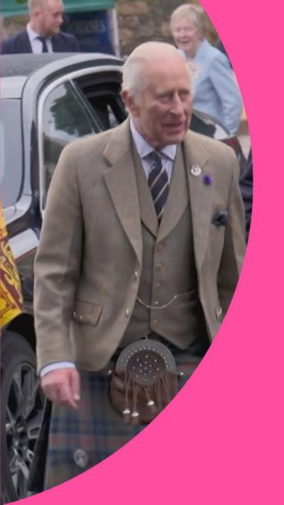 King Charles wearing a tweed jacket and a kilt