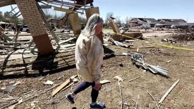 Teacher walks through rubble