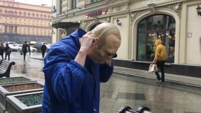 Russian protester Roman Roslovtsev wearing a Vladimir Putin mask