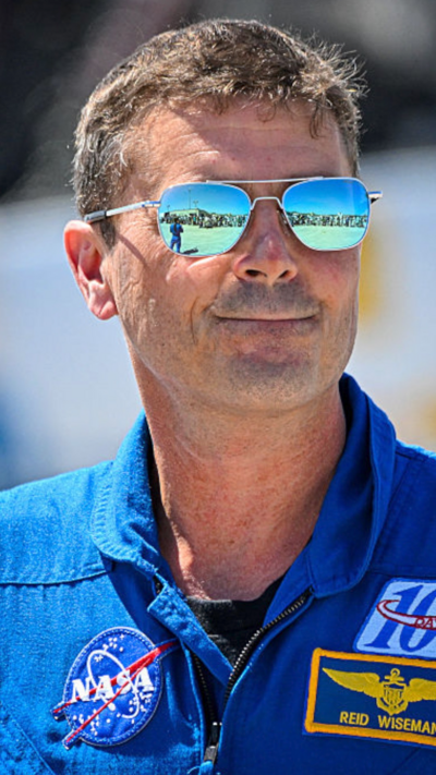 Reid Wiseman, a man with sandy hair and aviator reflective glasses in a Nasa blue uniform