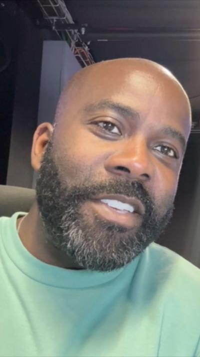 Melvin Odoom wears a green tshirt and looks at the camera