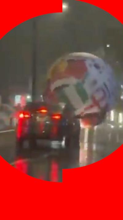 Giant inflatable World Cup football seen in front of a car