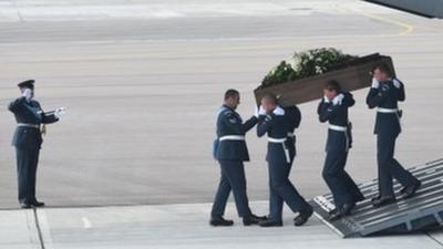 The coffin of Adrian Evans is taken from the RAF C-17 carrying the bodies of eight British nationals killed in the Tunisia terror attack at RAF Brize Norton