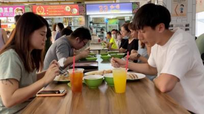 Two people eating at a hawker centre in Singapore