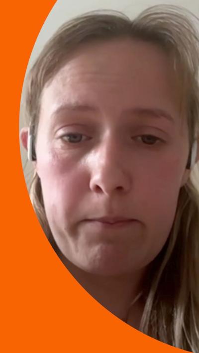Sarah Spooner looks upset as she looks at the camera during a video call. She has long, light-brown hair which is tied back