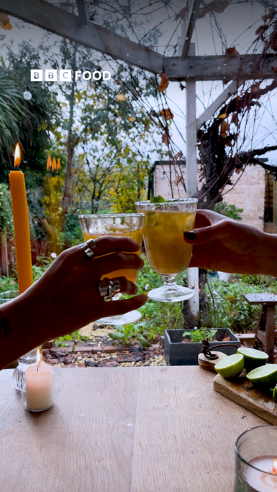 Two hands holding two glasses of cocktail doing a cheers