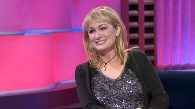 Caroline Aherne sitting smiling in the studio.