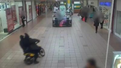 Motorbike driving through shopping centre