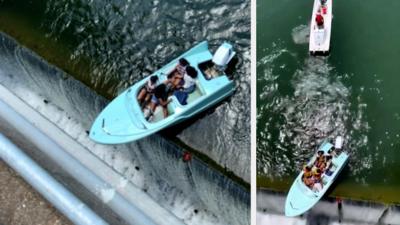 The four passengers were rescued after their boat got stuck at the top of the dam.