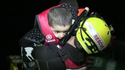 Rescue worker carries a young child