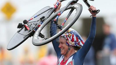 Kristin Armstrong holds up her bicycle