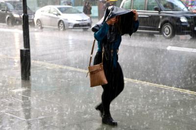 A person shelters from the rain on Oxford Street